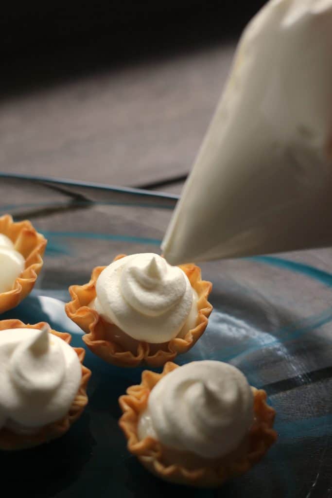 Mini Key Lime Tarts - Piping Cool Whip onto tarts with a Ziploc bag
