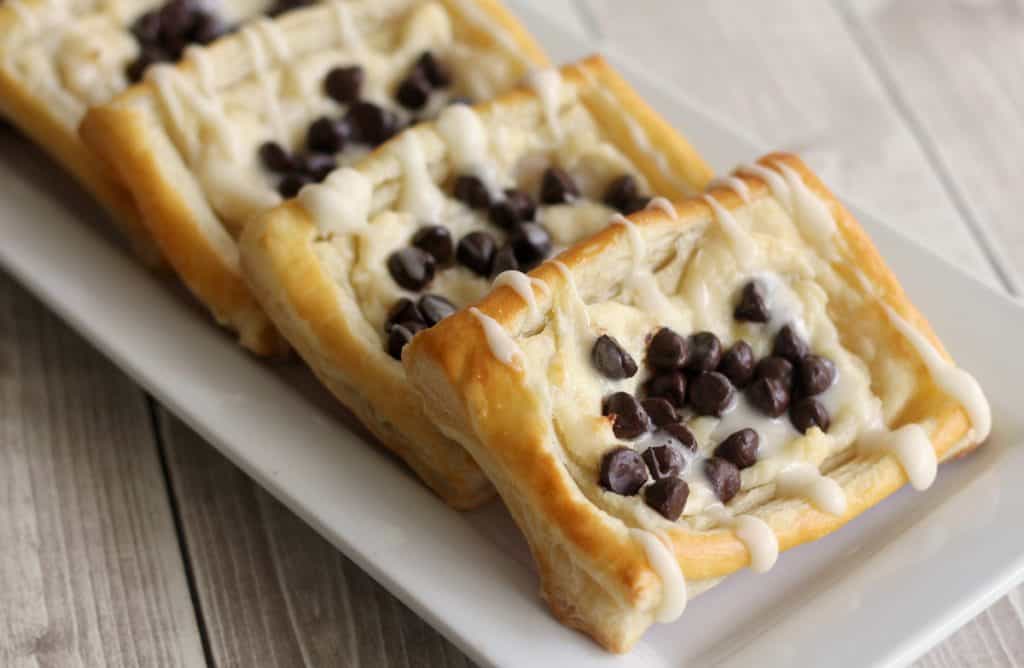 Chocolate Chip Cheese Danishes on a white plate on a light wood table