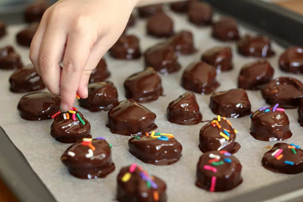 Topping Chunky Monkey Peanut Butter Banana Bites with sprinkles