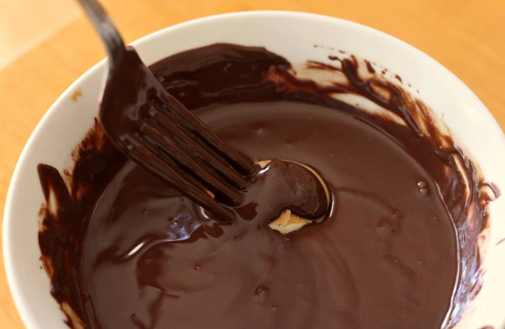 Dipping bananas in chocolate for Chunky Monkey Peanut Butter Banana Bites