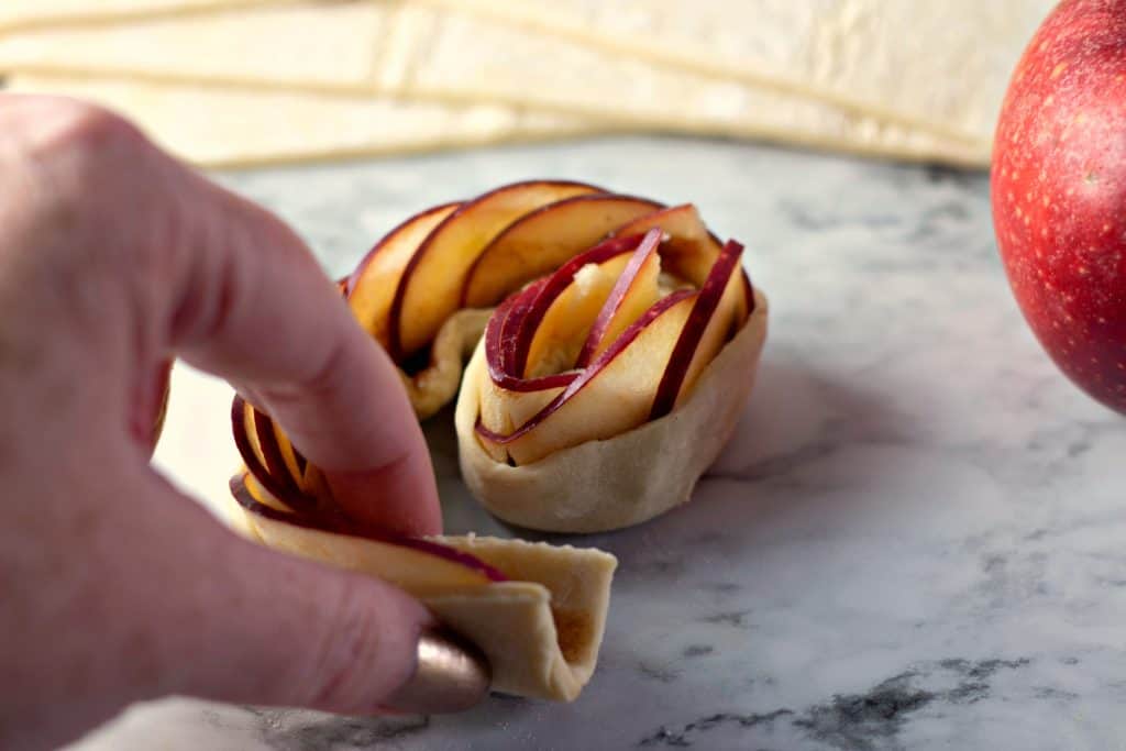 Coiling apples in puff pastry to make Caramel Apple Rose Tarts