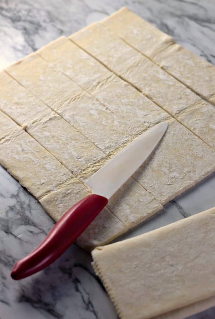 Slicing puff pastry into strips for making Caramel Apple Rose Tarts
