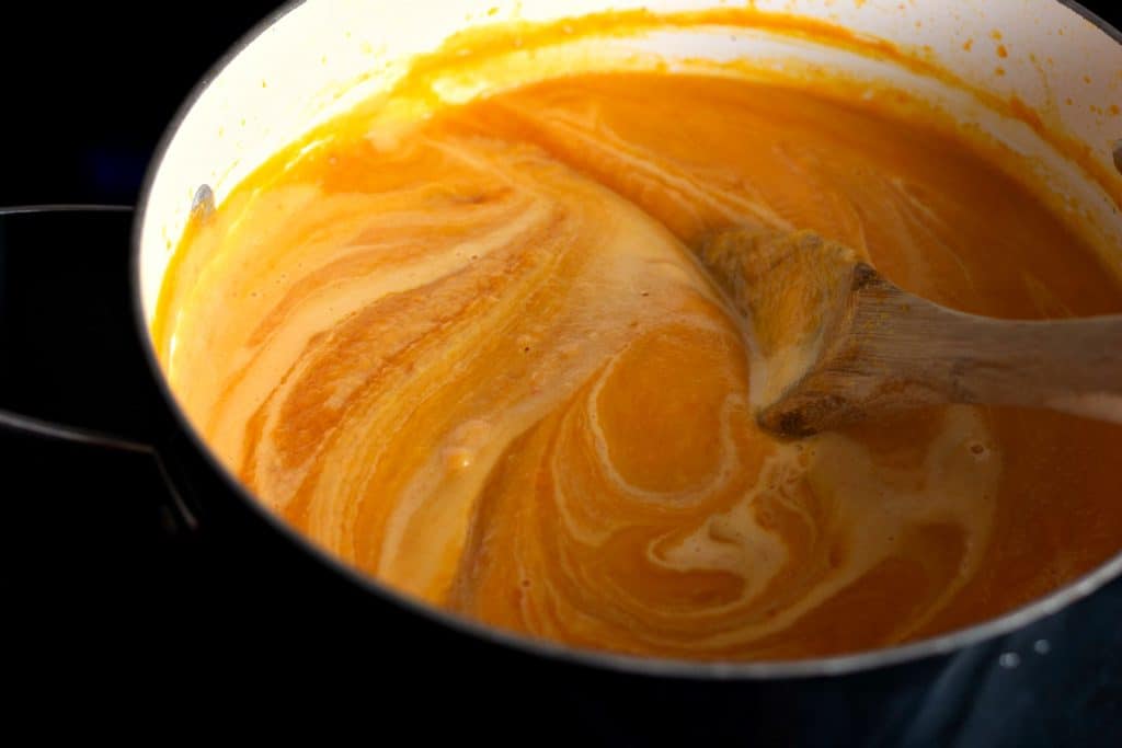 Stirring cream into the Savory Butternut Squash Soup
