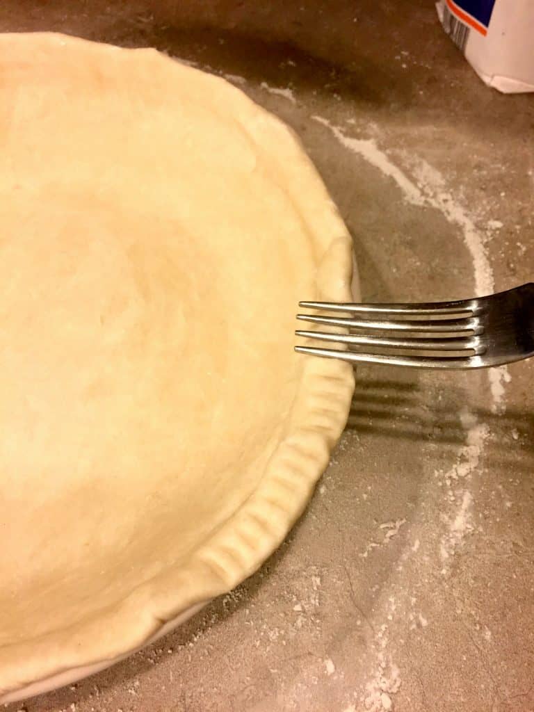 Using a fork to decorate the edges of a Homemade Shortening Pie Crust