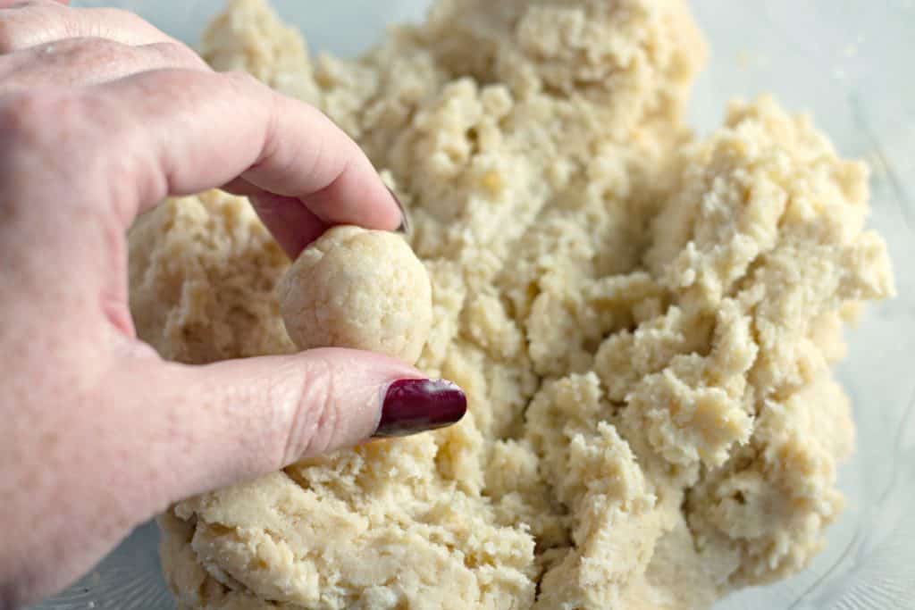 Rolling dough balls to make Christmas Sugar Cookie Truffles