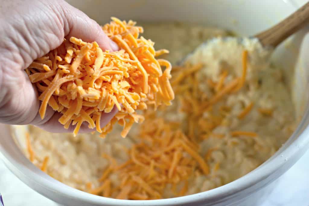 Sprinkling cheese into a white bowl