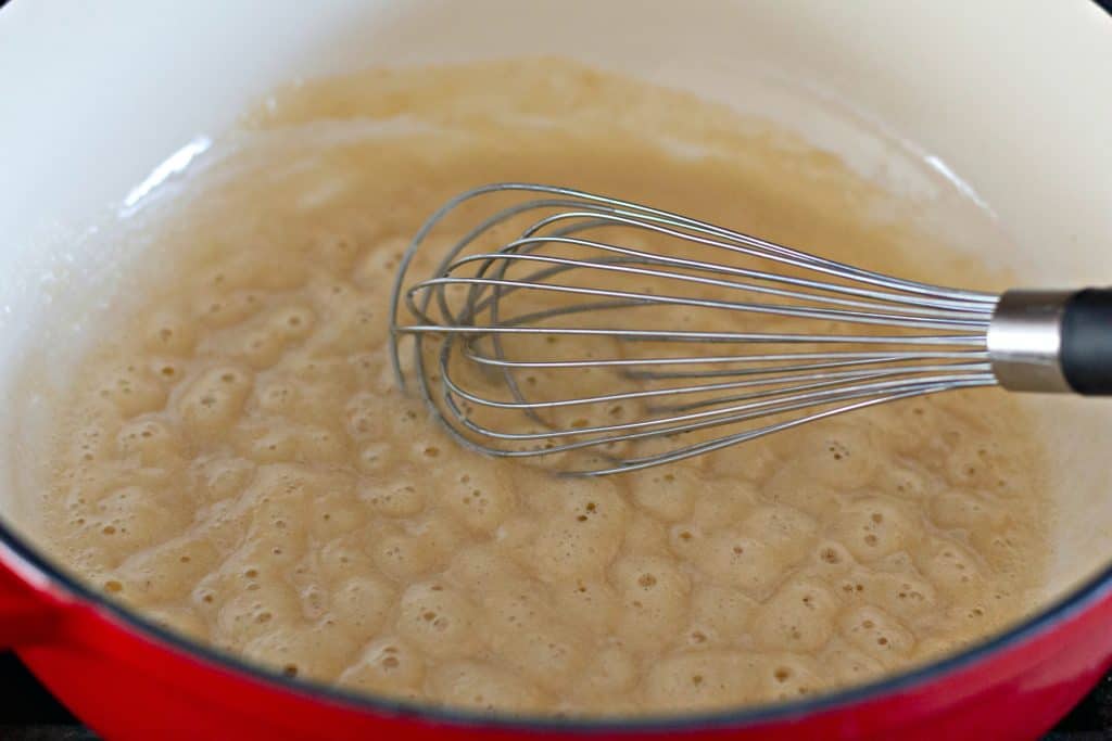 butter and flour bubbling in a pot with a whisk