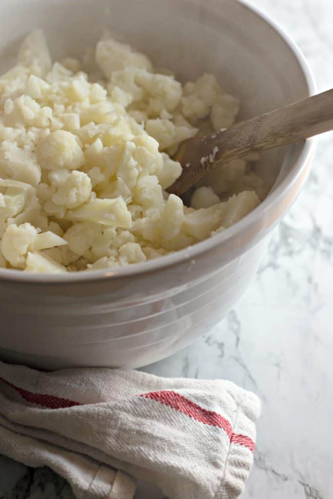 freshly cooked cauliflower in a white mixing bowl
