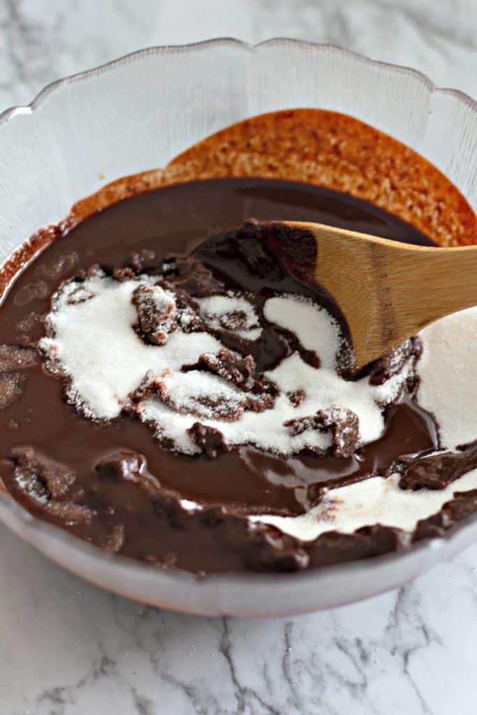 melted chocolate and sugar in a bowl with a wooden spoon