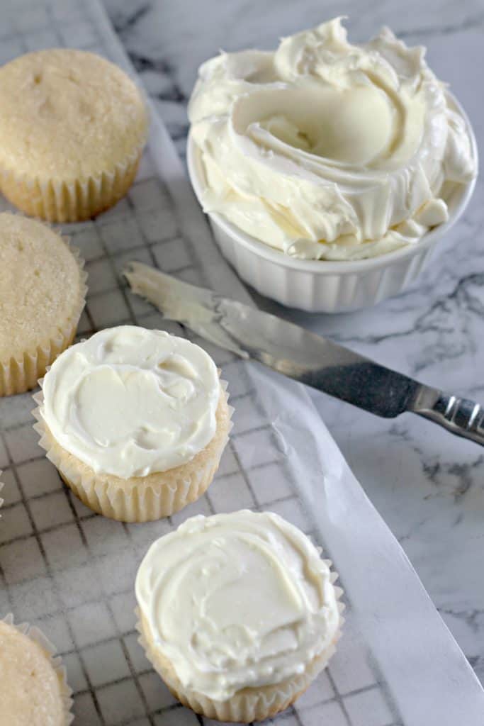 icing the cupcakes with homemade cream cheese frosting