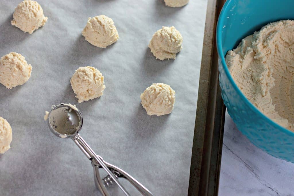 scooping cookie dough balls onto cookie sheet