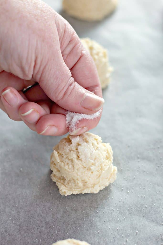 sprinkling sugar on cookie dough balls