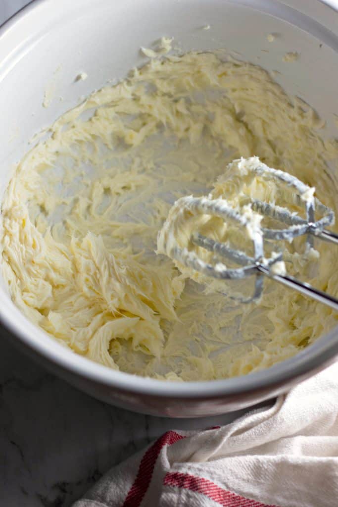 beating butter in a bowl with an electric mixer