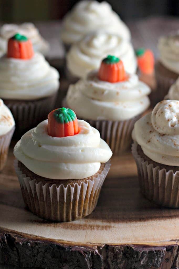 Pumpkin Cupcakes with Cream Cheese Frosting on a wooden tray