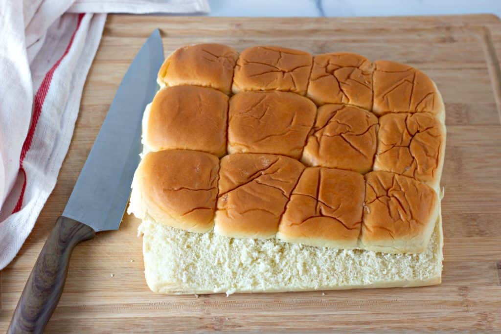 slicing the Hawaiian dinner rolls in half.