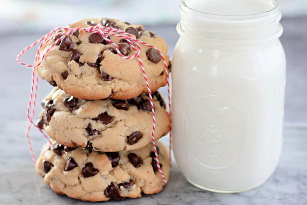 Bakery Style Giant Chocolate Chip Cookies with a jar of milk.