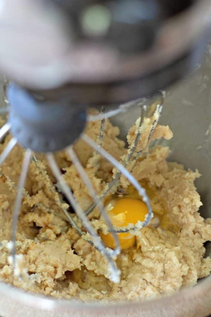beating an egg into cookie dough in a KitchenAid mixer.